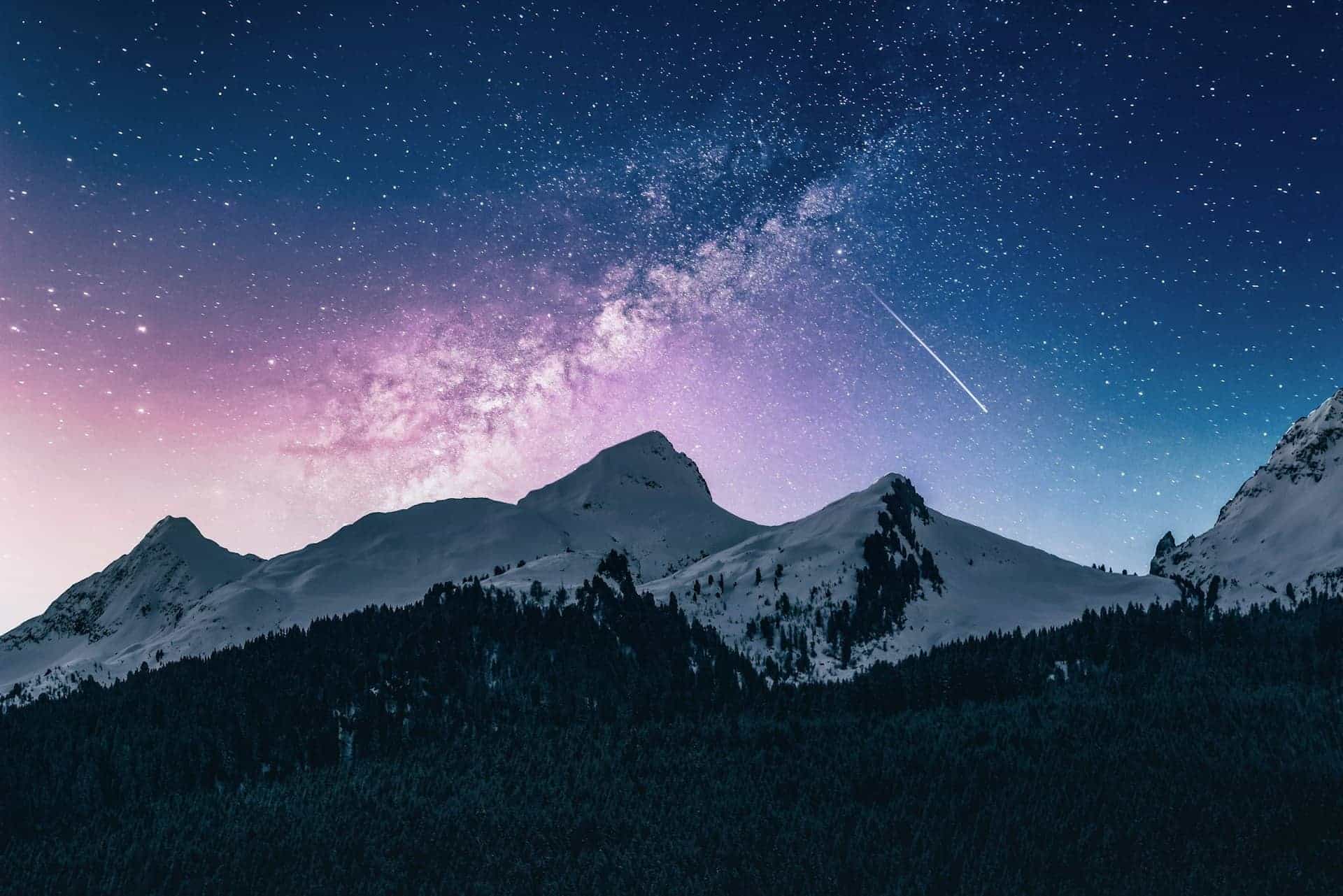Snow-capped mountains under a starry night sky