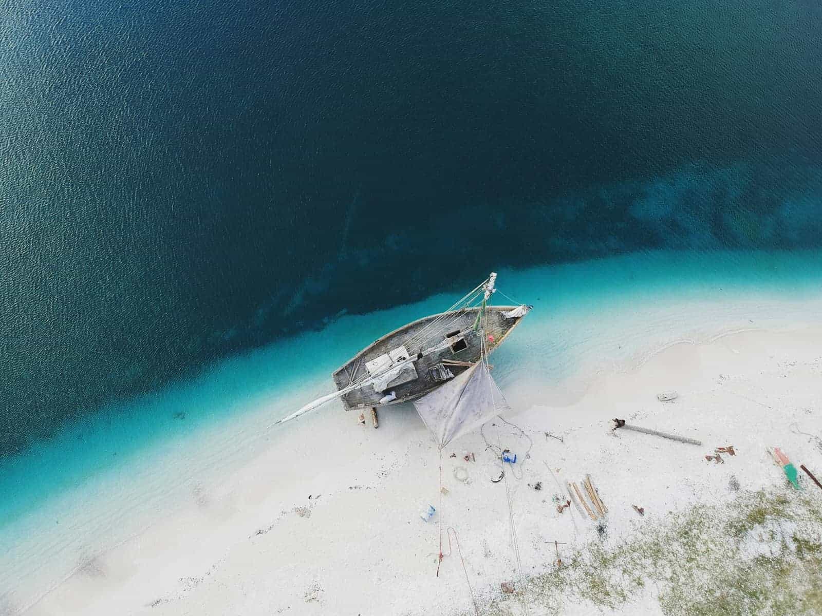 Aerial view of a boat on a turquoise shoreline